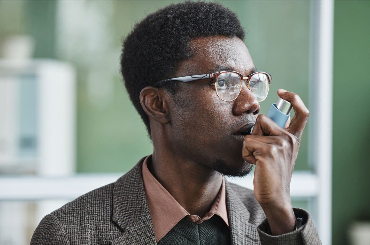 A man using an asthma inhaler